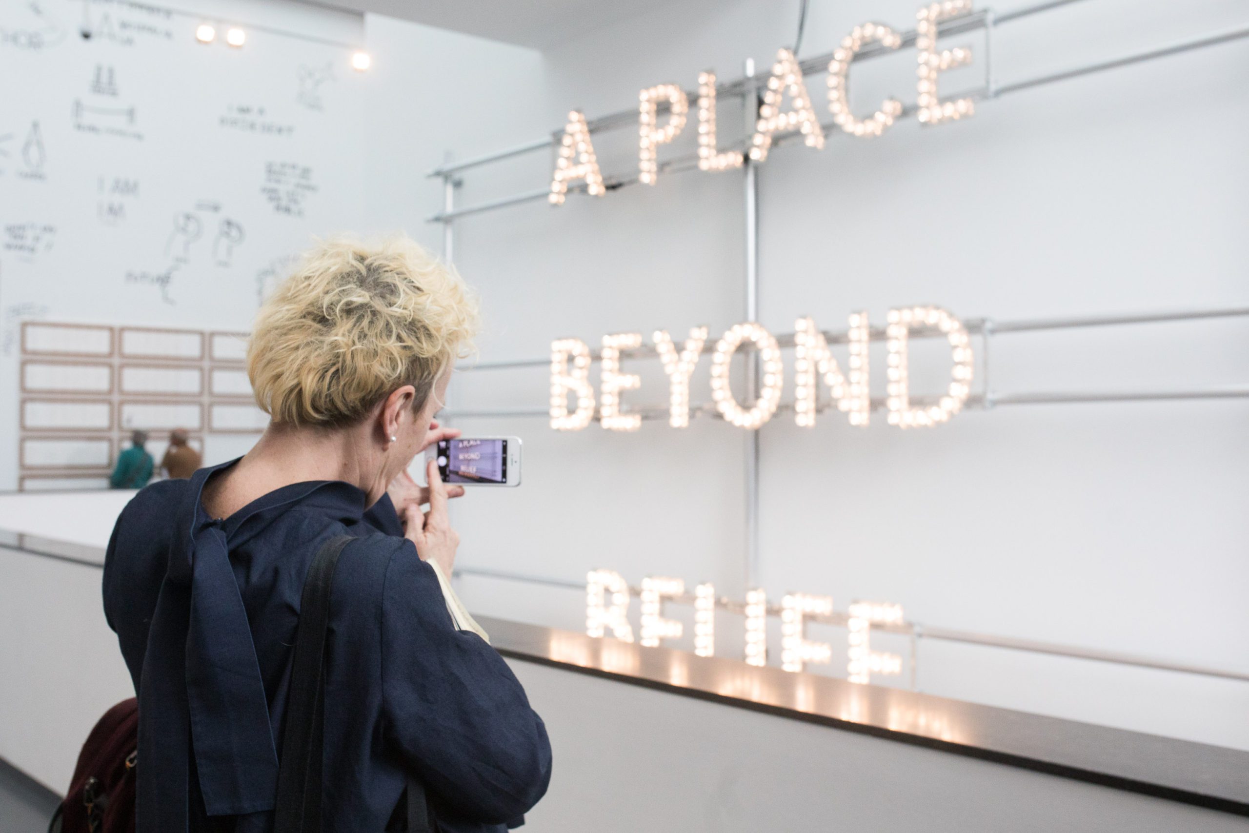 Adele Patrick stands in front of Nathan Coley's A Place Beyond Belief (2013) during visit to Van Abbe Museum, Eindhoven in 2018